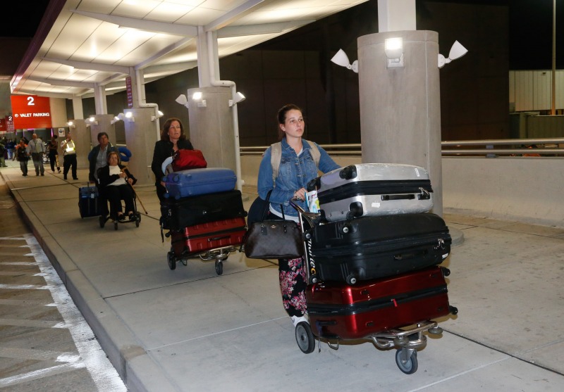 Passengers are allowed to leave Fort Lauderdale–Hollywood International Airport, Friday, Jan. 6, 2017, in Fort Lauderdale, Fla. A gunman opened fire in the baggage claim area at the airport Friday, killing several people and wounding others before being taken into custody in an attack that sent panicked passengers running out of the terminal and onto the tarmac, authorities said. (AP Photo/Wilfredo Lee)