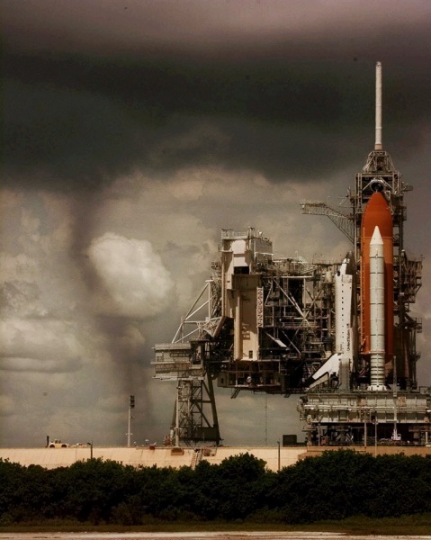 Space shuttle Columbia sits on the launch pad, Tuesday, July 20, 1999, as a tornado looms at left in the backgound at Kennedy Space Center, Fla. The flight of Columbia to deploy the Chandra X-ray Observatory on its five-day mission was delayed for 48 hours when the orbiter's hazardous gas detection system indicated a high concentration of hydrogen in Columbia's aft engine compartment. Following a preliminary evaluation, launch managers concluded the readings were false and rescheduled the launch for Thursday. The tornado dissipated seconds after the photo was taken. (AP Photo/Wilfredo Lee)
