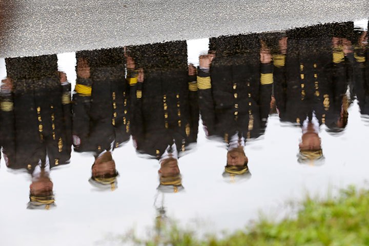 Firefighters are reflected in a puddle as they line the driveway of The Sanctuary Church after funeral services for Fort Lauderdale Fire rescue Lieutenant Kevin Johns, Tuesday, Oct. 7, 2014 in Fort Lauderdale, Fla. Johns, a 29-year veteran of the department was killed Sept. 30 in Boca Raton, Fla., as he was changing a flat tire on Interstate 95. (AP Photo/Wilfredo Lee)