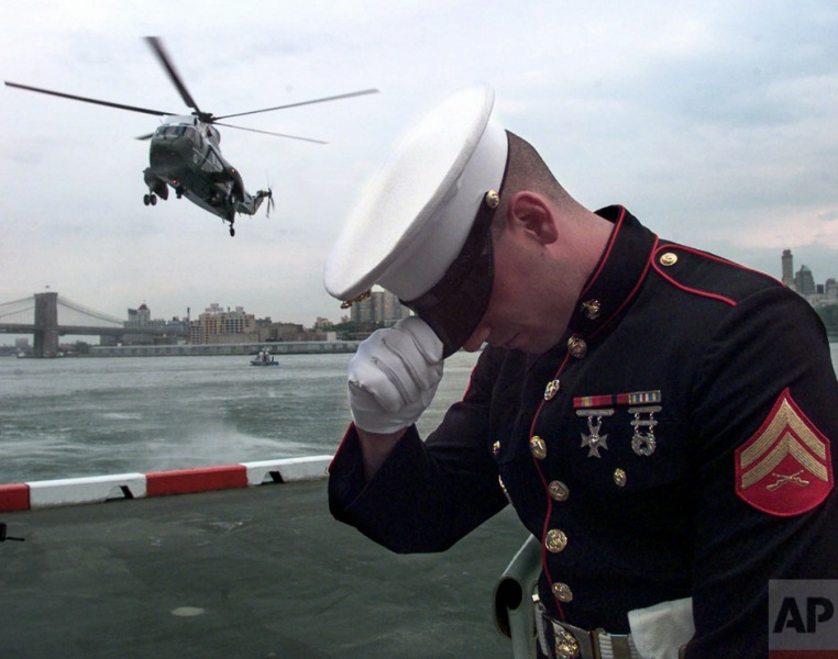A U.S. Marine guard reacts to the wind stirred up by the arrival of President Clinton's helicopter at the Wall Street Heliport, Thursday, June 26, 1997 in New York. The president arrived in New York to speak at the United Nations Earth Summit. (AP Photo/Wilfredo Lee)