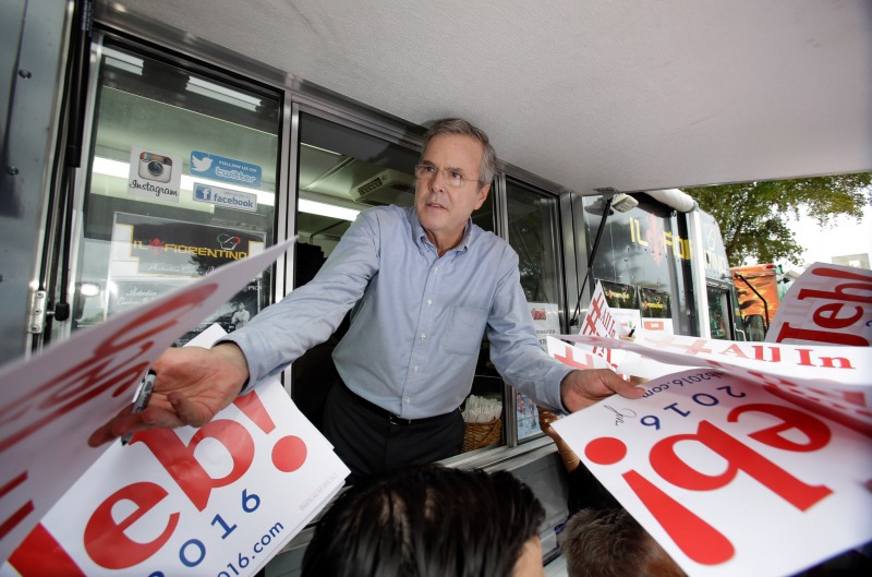 Former Florida Gov. Jeb Bush signs autographs from the window of a food truck after he formally announced that he would join the race for president with a speech at Miami Dade College, Monday, June 15, 2015, in Miami. (AP Photo/Wilfredo Lee)