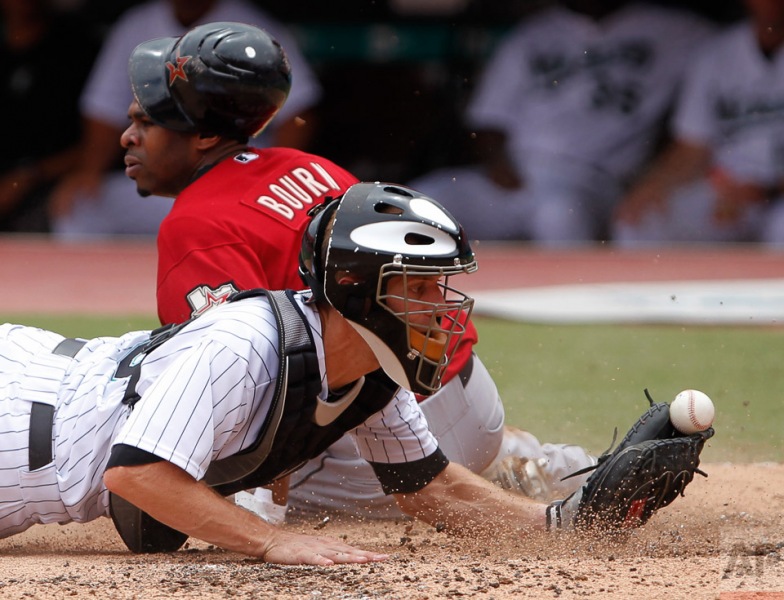 Florida Marlins catcher Brad Davis, foreground, is unable to retain the ball as he attempts to tag Houston Astros' Michael Bourn who slides into home plate during the third inning of a baseball game, Sunday, Aug. 22, 2010 in Miami. Bourn scored on a sacrifice fly by Hunter Pence. (AP Photo/Wilfredo Lee)