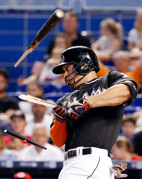 Miami Marlins' Giancarlo Stanton breaks his bat as he hits a single, scoring J.T. Realmuto, during the eighth inning of a baseball game against the Cincinnati Reds, Saturday, July 9, 2016, in Miami. (AP Photo/Wilfredo Lee)