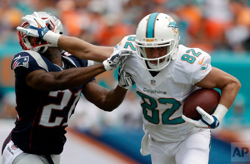 Miami Dolphins wide receiver Brian Hartline (82) defends against a tackle by New England Patriots cornerback Malcolm Butler (21), during the first half of an NFL football game in Miami Gardens, Fla., Sunday, Sept. 7, 2014. (AP Photo/Wilfredo Lee)