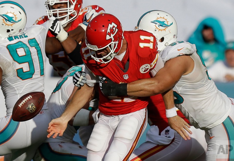 Kansas City Chiefs quarterback Alex Smith (11) fumbles the ball under pressure from Miami Dolphins defensive tackle Jared Odrick (98) during the second half of an NFL football game, Sunday, Sept. 21, 2014, in Miami Gardens, Fla. (AP Photo/Wilfredo Lee)